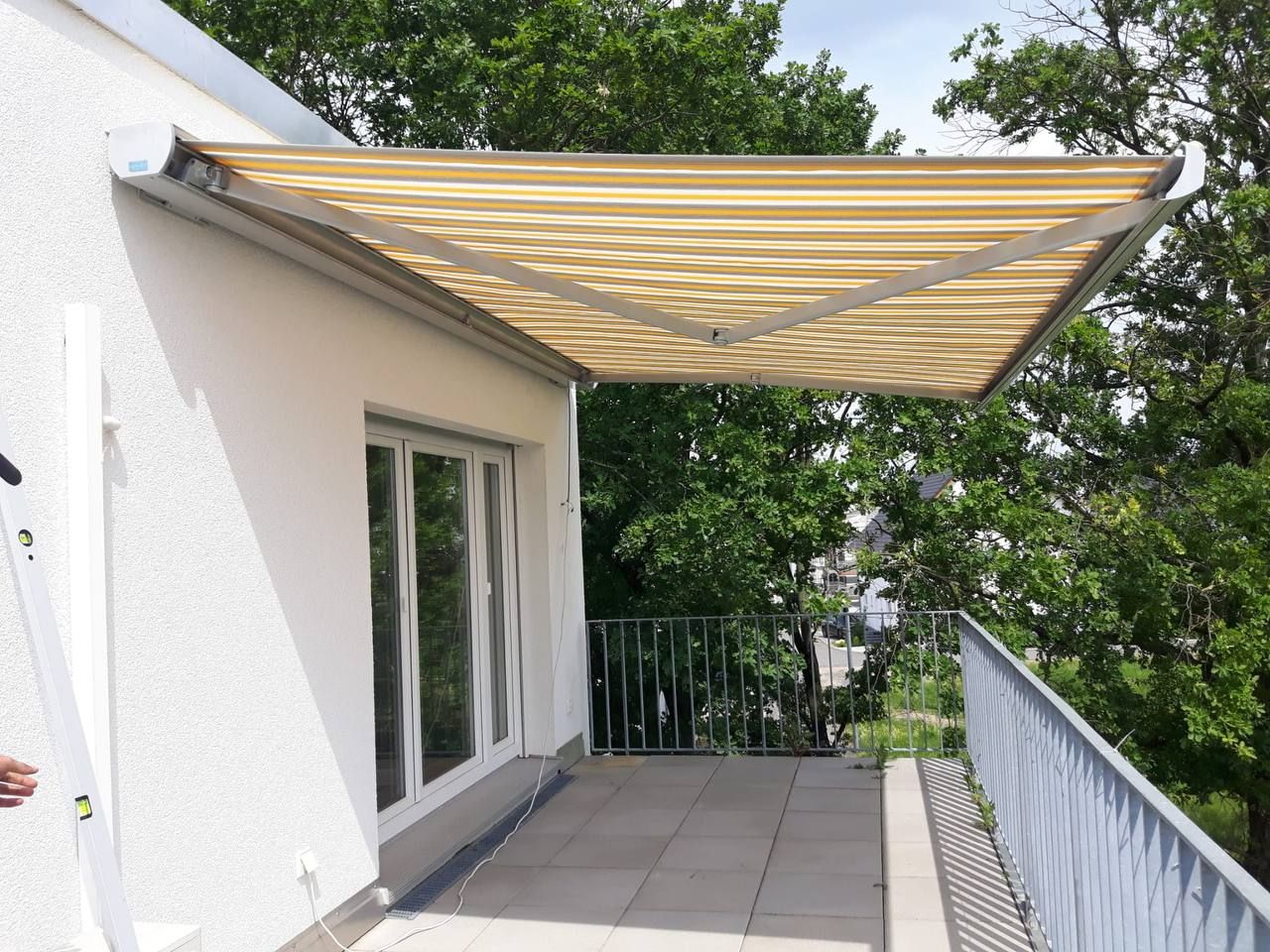 Gelenkarmmarkise über einem Balkon